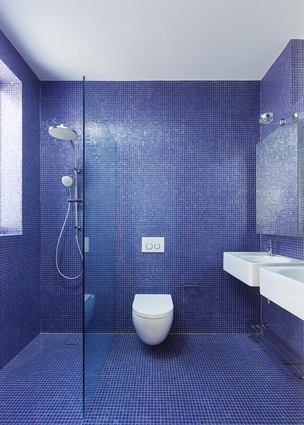The use of colour in the bathrooms provides a playful note in an otherwise restrained material palette.