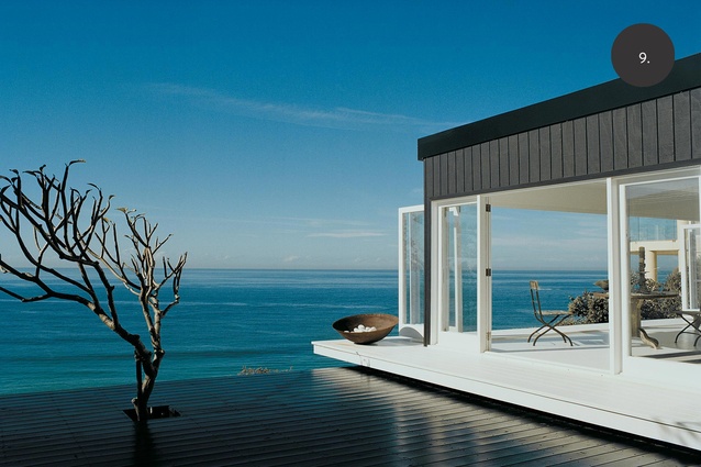 The black-painted timber deck frames a Frangipani tree.