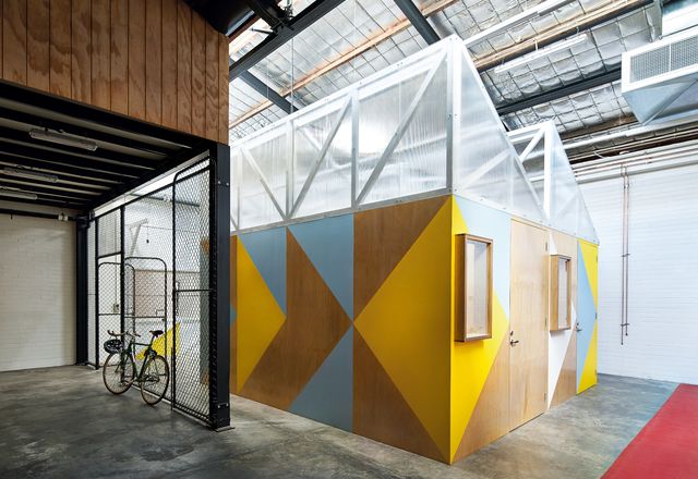 Five small-scale workshop pods act as a tiny precinct within the warehouse space.