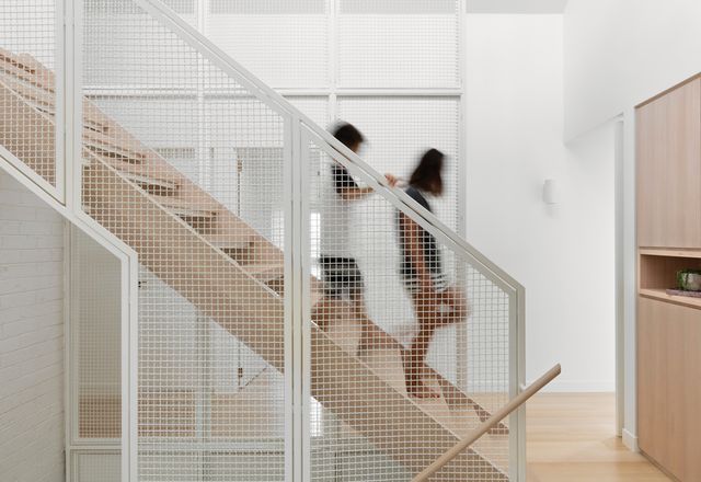 A wire-mesh balustrade provides visual and acoustic connection between levels.