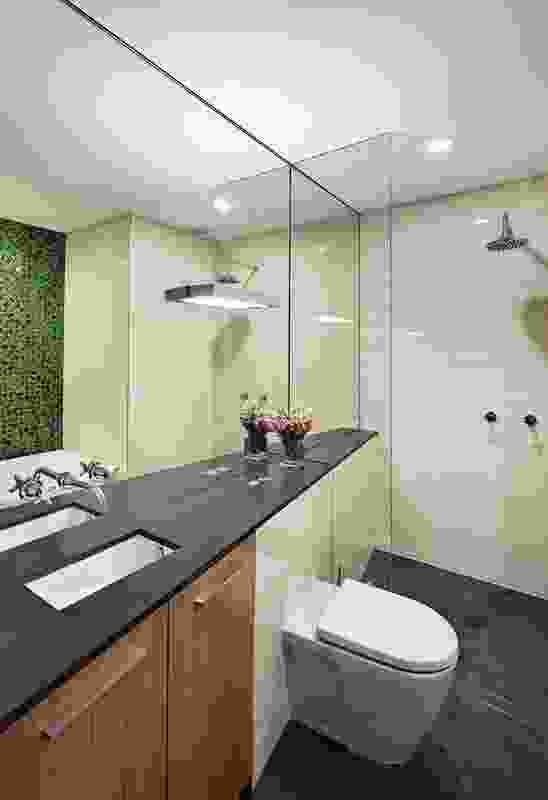The main bathroom includes a feature wall of green mosaic tiles.