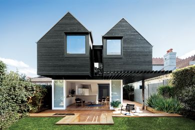 Twin first-floor pavilions and ample openings connect the house to the garden and sky.