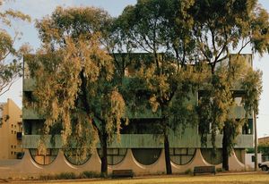 The south facade overlooks a park and Fitzroy Town Hall. Two courtyard houses occupy the top floor, their courtyards seemingly carved out of the glazing.