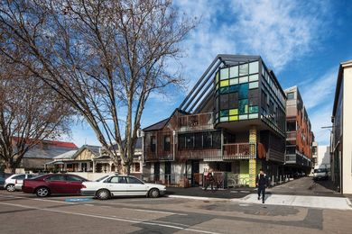 A colourful, glazed, third-floor projection breaks the flush wall.