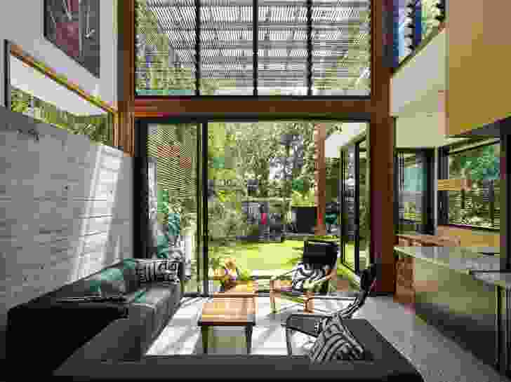 The garden room opens to the outdoors, visually linked by the rough concrete wall.