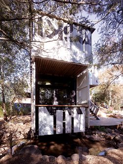 North-east elevation, with the balcony off the study below. Here the containers’ end doors are reused structural blinkers, while removed side walling becomes balustrading.Images: Peter Bennetts 