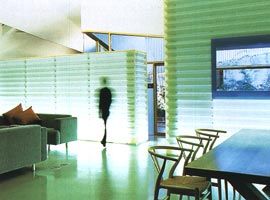 Looking across the living and dining areas to the translucent glowing storage and kitchen boxes.
The bedroom courtyard is beyond.