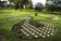 Three free-form garden beds hold a repetition of flower-shaped pavers.