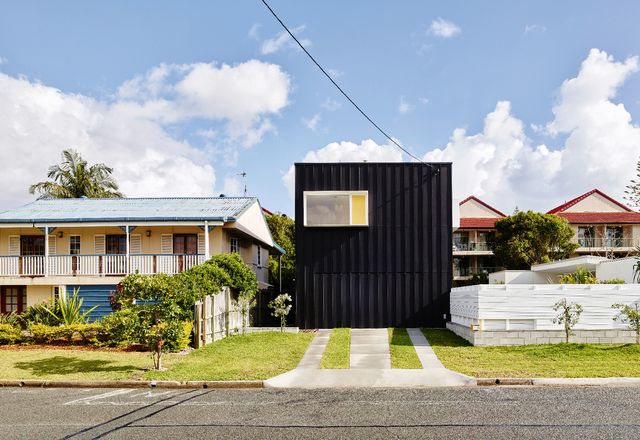 When viewed from the street, the house appears as a dark box clad in compressed fibre cement sheeting and striped with battens.