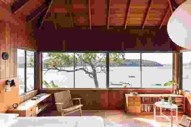 The main bedroom, under a steeply pitched roof, offers views north up the Pittwater to Barrenjoey Lighthouse.