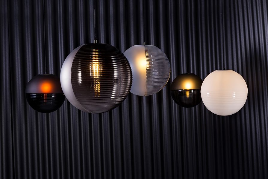 The blown-glass spheres of the Stellar pendant lighting collection for Pulpo are divided into hemispheres of textured and smooth.
