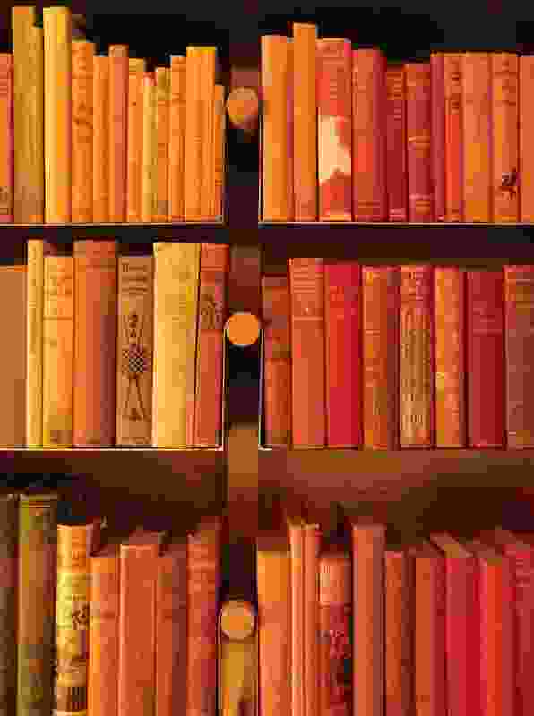 Antiquarian books are ordered by colour above the fireplace.