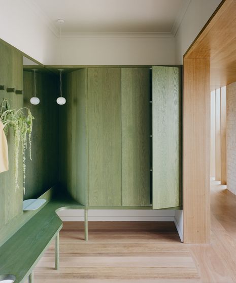 An entry foyer with custom green joinery is a place for pause on departure and arrival.