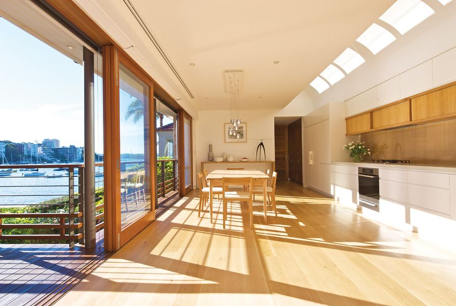 The kitchen and dining area overlooks a harbour beach in Sydney.