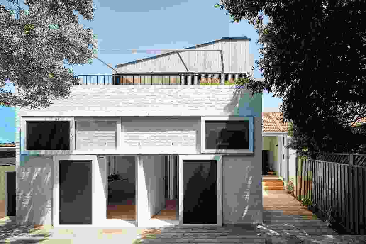 The two rear bedrooms are connected to a deck and terraced garden through a series of oversized openings.