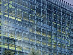 Detail of the expansive glazing on the western side of the building. The transparency of this public face contrasts with the screened judicial “veil” on the eastern side.