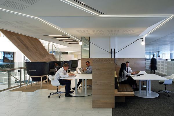 Communal work tables and meeting rooms inside ANZ workplace in Sydney designed by Hassell. 
