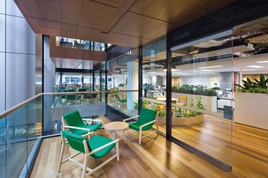 Informal meeting areas jut out into the peripheral void above the stair.