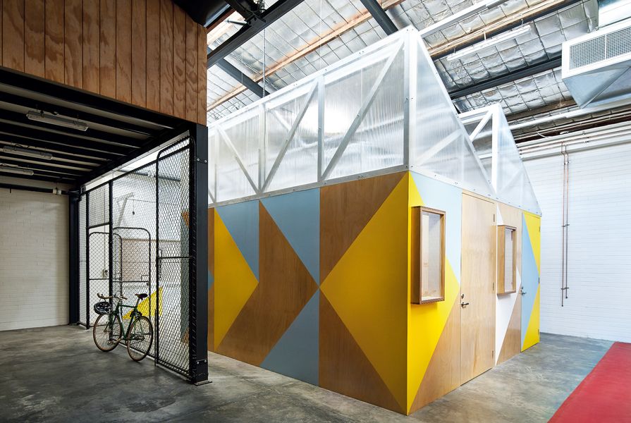Five small-scale workshop pods act as a tiny precinct within the warehouse space.