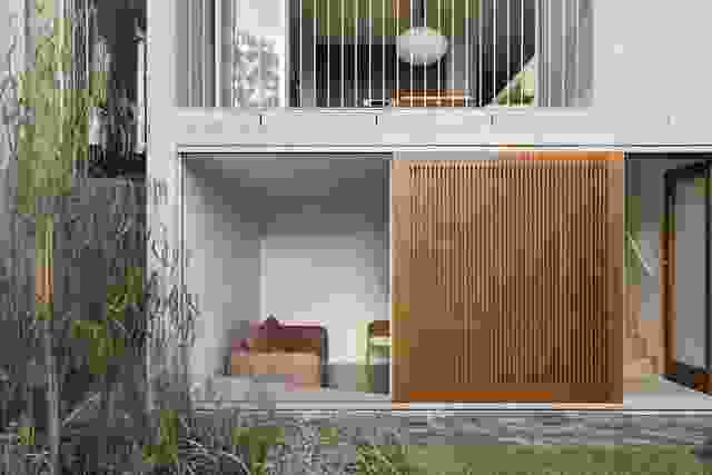 The lower-ground lounge is partially sunken and connects to the garden through large timber screens.