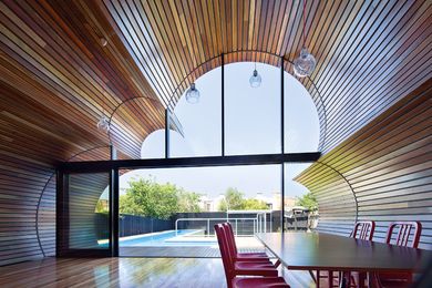 The timber-lined, cloud-shaped profile extrudes towards the garden.