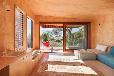 The interior is clad in hoop pine ply, which has a cocooning effect; extensive glazing balances this with a sense of openness.