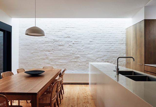 A long skylight in the dining space illuminates the restored brickwork to dramatic effect.