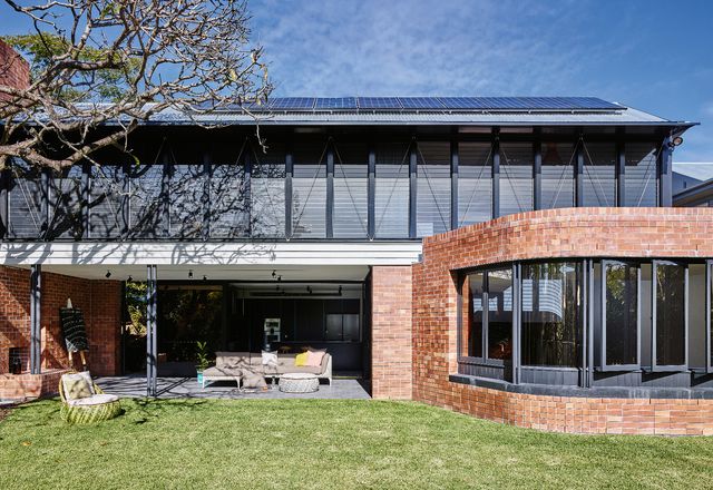 The two-storey extension fits neatly into its garden surrounds, using a large mango tree as a focal point.