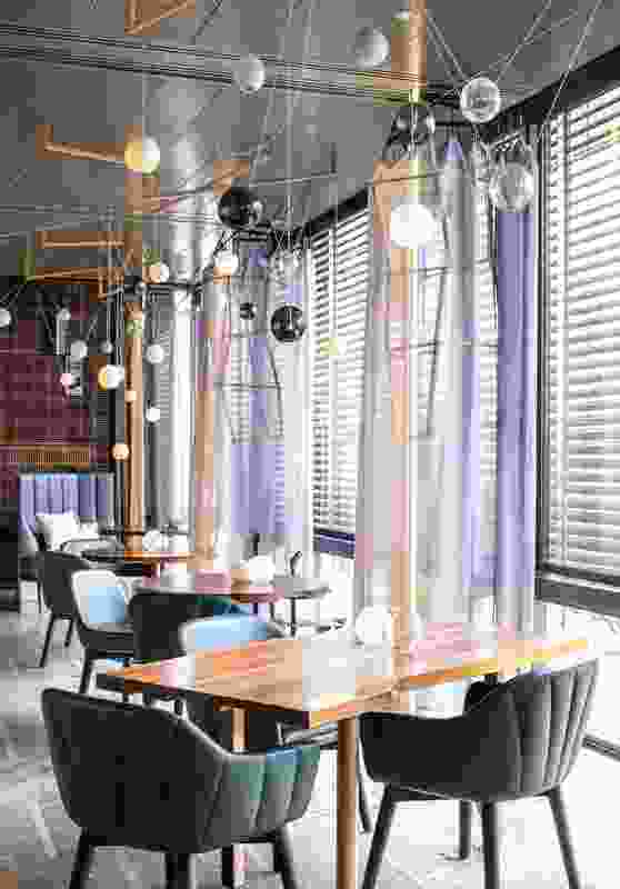 Illuminated pillars layered with metal concertina girdles and gauze surround the dining room.