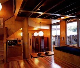 Dining and kitchen seen from the living area, with the entry verandah seen through the windows to the right. 