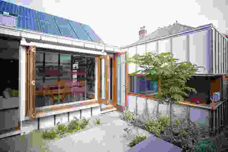 A desk-height corner window in the study allows a view through a courtyard and TV room, to the pool.