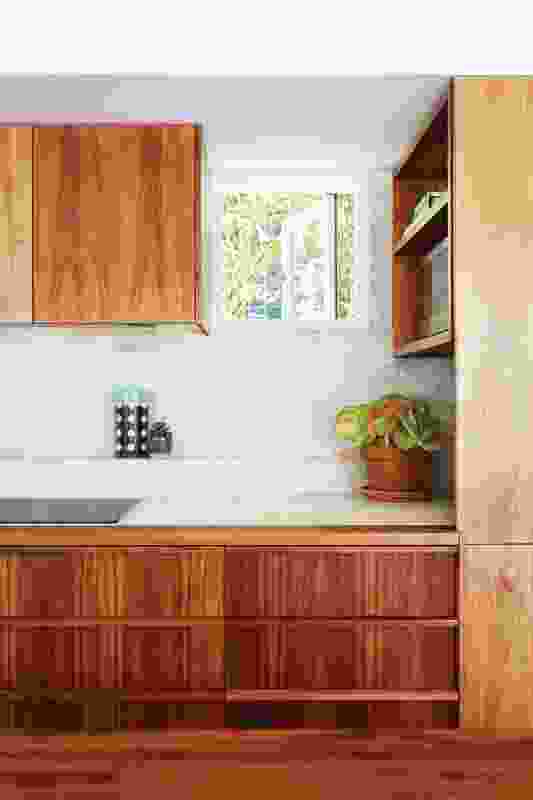 A strategically placed picture window in the kitchen offers sunlight and a glimpse of nature while maintaining privacy.

