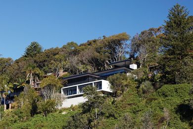 The house is perched precariously on a steep embankment.