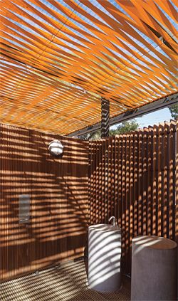 The pavilions are roofed with woven strips of orange webbing, which cast vibrating shadows. Image: Brett Boardman