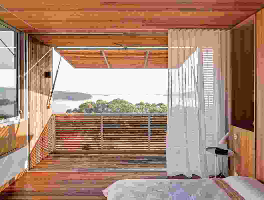 Operable screens adjoining the upstairs bedroom provide shade and capture views to the lake.