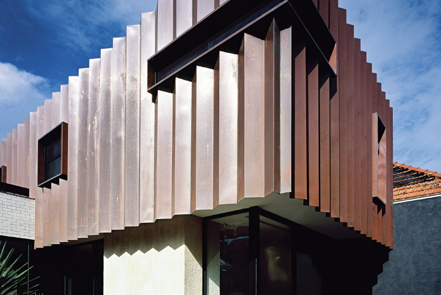 The addition’s pleated copper facade complements the tones of the existing red brick Federation house.