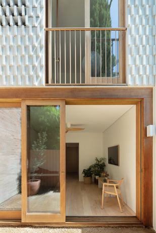 The living spaces are pushed towards the rear facade of the narrow house, maximizing outlook and access to natural light.