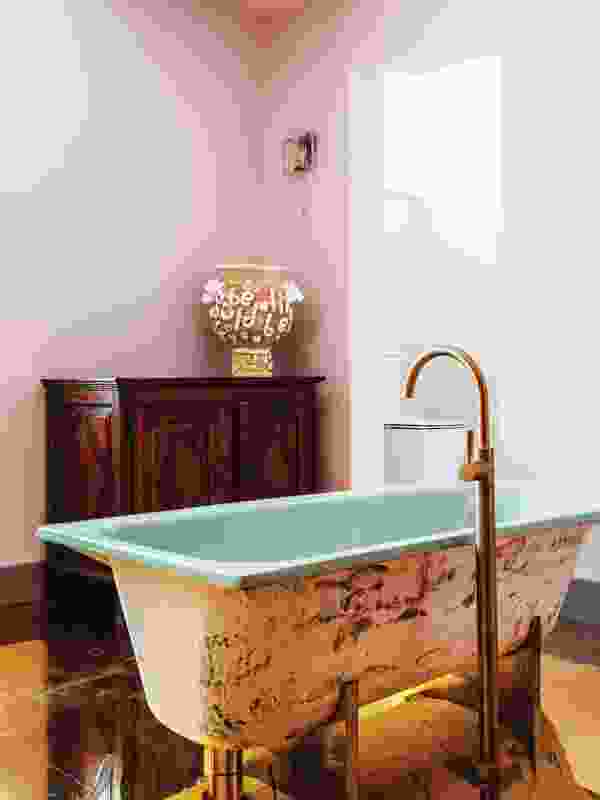 In a light, humorous touch, a 1950s bath sits on a brass cradle, a play on a claw foot fitting.