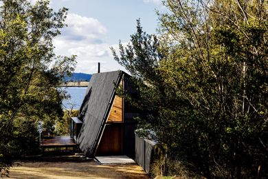 On a sheltered headland, nestled among the native vegetation, the newly designed addition recedes into the site.