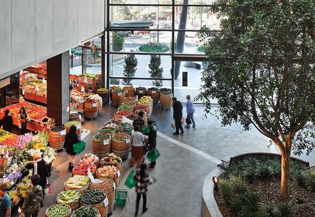 At Highpoint’s eastern entry, mature trees and a greengrocer lend a “public square” feel.