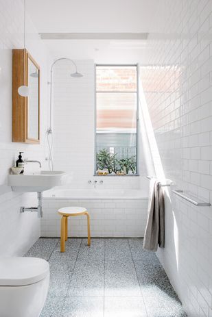 Efficient planning, including a bath that fits the width of the room and a wall-hung cabinet, helps to achieve an uncluttered bathroom.