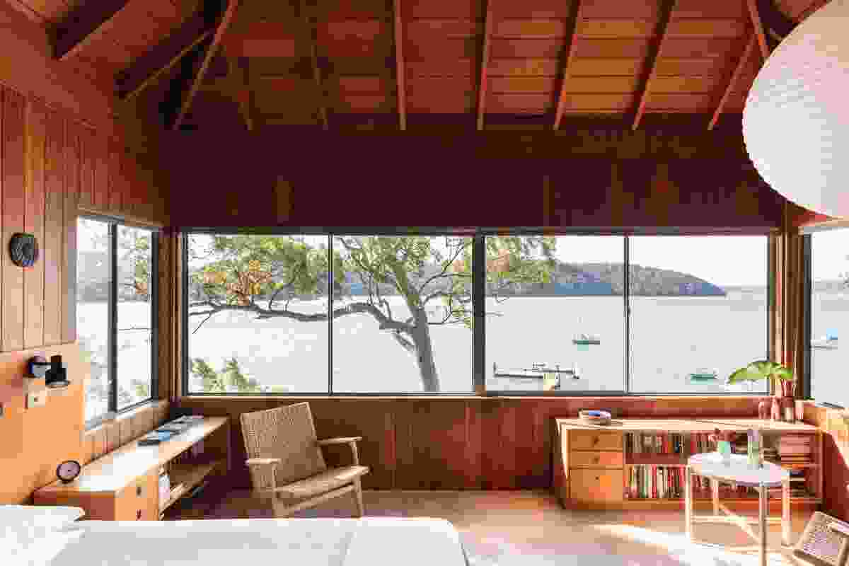 The main bedroom, under a steeply pitched roof, offers views north up the Pittwater to Barrenjoey Lighthouse.