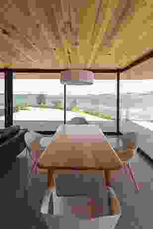 The dining room offers a protective space to watch light play across the bay and landscape.