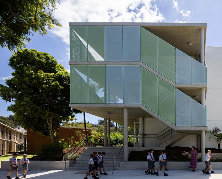 Facing the street, the end of the red-brick building is partially wrapped by a generous staircase and perforated panels.
