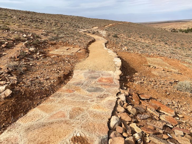 Formed of local dry stone, the meandering path to the Ediacaran fossil beds at Nilpena blends into the landscape.