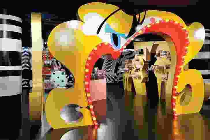 An arch featuring lady gaga’s scarlet lips leads into a candy shop selling branded merchandise.