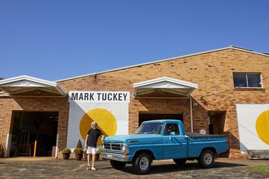 Mark Tuckey with the blue F-100 truck that he used when he first started his business in 1990.