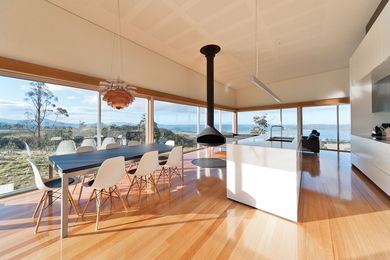 The kitchen and dining room are filled with light and focused towards views framed by glazing.