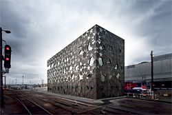 The building is constrained on all sides by rail tracks, with primary access via a stair from the service tunnels below.