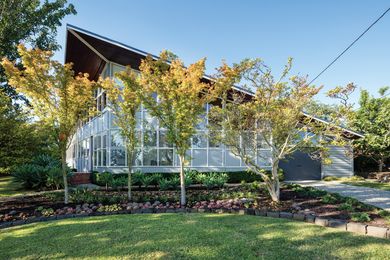 The roof soars skyward, “like the opening of a bird’s beak,” over a gigantic window wall.